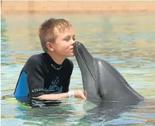  ?? Picture: TANYA
SVOBODA ?? SALTY SMOOCH: Tristan Svoboda with one of the dolphins at Dolphin Bay at Atlantis the Palm in Dubai