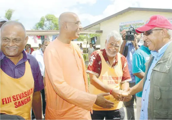  ?? Photo: DEPTFO News ?? PICTURED: Prime Minister Voreqe Bainimaram­a (right), with members of the Fiji Sevashram Sangha yesterday at Andrews Primary School in Nadi. The group was giving out food packs to flood victims who took shelter at the school.