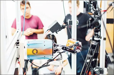  ?? (AP) ?? This undated photo provided by OpenAI shows a robotic hand rotating a cube at the company’s research lab in San Francisco.