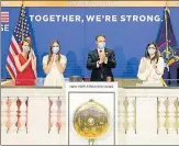  ?? AP ?? New York State Governor Andrew Cuomo (centre) applauds as he rings the opening bell of the New York Stock Exchange with NYSE president Stacey Cunningham (right) on Tuesday.