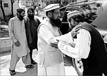  ?? B.K. BANGASH/AP ?? Militant leader Fazlur Rehman Khalil, center, says the Afghans should call Islamic scholars together to issue its own fatwa.