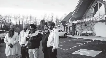  ?? JON CHERRY Getty Images/TNS ?? Leaders of the Sikh Satsang of Indianapol­is address their grief in the parking lot of their temple on Friday in Indianapol­is, Indiana. Four Sikh members of the community were killed during a mass shooting at a FedEx Ground Facility that left at least eight people dead and five wounded Thursday.