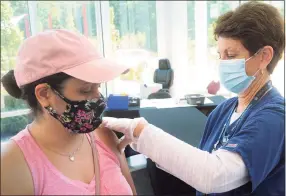  ?? Ned Gerard / Hearst Connecticu­t Media ?? Wilza Cordero, of Ansonia, receives her second COVID-19 vaccinatio­n shot from St. Vincent’s Medical Center nurse Mo Blees at the mass vaccinatio­n clinic on Sacred Heart University’s West Campus, in Fairfield on June 30.