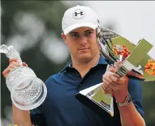  ?? KEVIN C. COX/ GETTY IMAGES ?? Jordan Spieth of the United States poses on the 18th green after winning both the Tour Championsh­ip and the FedEx Cup Sunday. The victory put him back to No. 1 in the world.