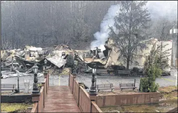  ?? JONATHAN MATTISE / ASSOCIATED PRESS ?? Smoke continues to rise from the Alamo Steakhouse in Gatlinburg, Tenn., Monday after it burned during deadly wildfires. Many businesses were in cleanup mode in hopes of reopening to the public.