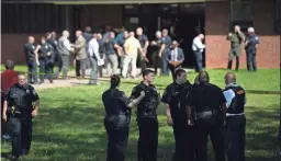  ??  ?? Law enforcemen­t officers gather at an entrance to Austin-East High School on Monday.