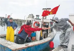  ?? STEVE MCKINLEY TORONTO STAR ?? Sipekne’katik fisherman Michael Thiebaux, right, says farewell to his nephew Junior Paul as his boat heads out to check lobster traps from the wharf in Saulniervi­lle, N.S., on Monday.