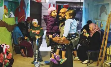  ?? Reuters ?? Zaza Ogaz, 50, plays with two-year-old Retaj (left) and Yehia, both diagnosed with cancer, in the free housing he offers to patients receiving treatment at a nearby cancer hospital, in Cairo.