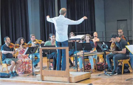  ?? FOTO: EPD ?? In der Aula der Waldorfsch­ule in Frankfurt am Main findet diese „Bridges“-Orchesterp­robe mit dem Dirigenten Martin Wettgesam statt.