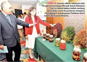  ?? GambarBern­ama ?? TERESA (kanan) diberi taklimat oleh Pengerusi Lembaga Minyak Sawit Malaysia Tan Sri Mohd Bakke Salleh tentang jenis baka sawit di pameran sempena Persidanga­n Kebangsaan Pekebun Kecil Sawit 2018 pada Khamis.