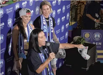  ?? PHELAN M. EBENHACK/ORLANDO SENTINEL ?? Ali Krieger, lef, speaks to fans who turned out to greet her and fellow U.S. women’s national team members Alex Morgan, center, and Ashlyn Harris on Tuesday in Orlando. The three will rejoin the Orlando Pride this week.