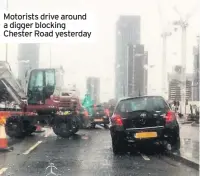  ??  ?? Motorists drive around a digger blocking Chester Road yesterday