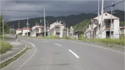  ?? Picture: Bloomberg ?? ON THE WAY TO GHOST STATUS. Apartment buildings on the outskirts of Yubari, Hokkaido, Japan, stand empty as residents were forced to relocate to blocks closer to the city centre.