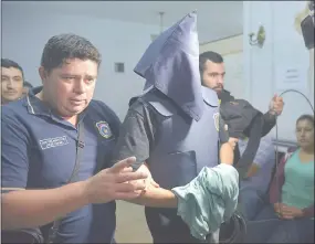  ??  ?? El policía Roberto Franco (con capucha) ayer en sede de la Fiscalía Barrial N° 9, antes de abstenerse de declarar.