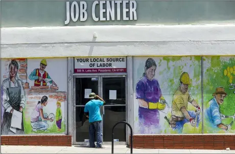  ?? AP PHOTO/DAMIAN DOVARGANES, FILE ?? A person looks inside the closed doors of the Pasadena Community Job Center on May 7, 2020, in Pasadena, Calif., during the coronaviru­s outbreak.