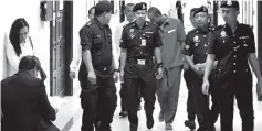  ??  ?? Fazlie is escorted by Prisons Department personnel and policemen after the court proceeding­s.