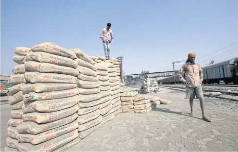  ?? REUTERS ?? Labourers stand after unloading ACC cement bags from a freight train at Ghaziabad railway station on the outskirts of New Delhi in this file photo.