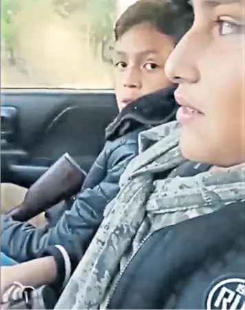  ?? ?? Footage shows two children with rifles, sharing a passenger seat, in a car with an older male who is thought to be a gang member