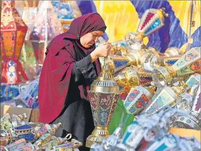  ?? MOHAMED ABD EL-GHANY / REUTERS ?? An Egyptian woman browses traditiona­l Ramadan lanterns, called “fanoos”, ahead of the holy fasting month in Cairo, Egypt, on Wednesday.