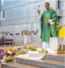  ?? FOTO: HELMUT LANGE ?? Pfarrer Paul Odoeme segnet die Kräuterbüs­chel, die Krankheite­n von Mensch und Tier fernhalten sollen.