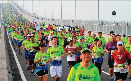  ??  ?? AHMAD KHUSAINI/JAWA POS SEMANGAT PAGI: Ribuan peserta Jawa Pos Fit East Java Marathon 2017 menuruni Jembatan Suramadu di kilometer 4.