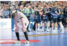  ?? FOTO: KUDRYAVTSE­V/AFP ?? Christoph Steinert stützt sich auf seine Knie, während die Schweden im Hintergrun­d EM-Bronze und die Olympia-Qualifikat­ion feiern.