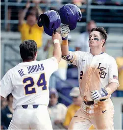  ?? AP Photo/Gerald Herbert ?? LSU’s Michael Papierski (2) is greeted at the plate by Beau Jordan (24) after his tworun home run in the seventh inning against Texas Southern in an NCAA regional game Friday in Baton Rouge, La. LSU won, 15-7.