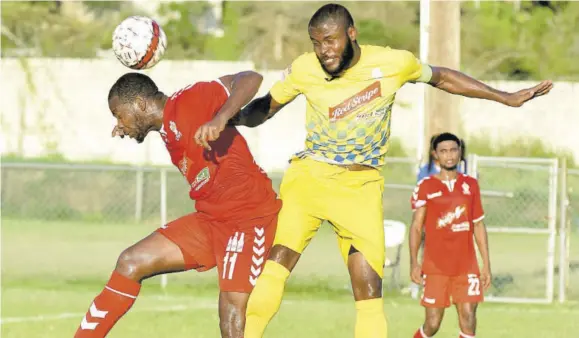  ?? (Photo: Garfield Robinson) ?? University of the West Indies player Dawyne Smith (left) wins an aerial challenge against Harbour View’s Nicholas Beckett during yesterday’s Red Stripe Premier League match at Mona Bowl.
