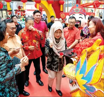  ?? — Photos by Chimon Upon ?? Fatimah performs eye-dotting on a dragon’s head to mark the opening of the Lunar New Year Bazaar at Plaza Merdeka.