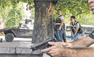  ??  ?? ON EDGE: Police draw their weapons outside an Ankara courthouse Monday as tensions remain high in Turkey while President Recep Tayyip Erdogan (left) cleanses the government and military of coup plotters.