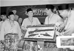  ??  ?? Ismail Sabri receiving a souvenir from Sepang Umno Youth chief at the opening of the Sepang Umno delegates conference. - Bernama photo