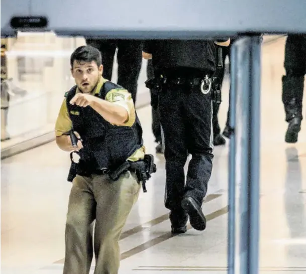  ??  ?? Polizisten und Terrorkomm­andos sichern das Einkaufsze­ntrum im Nordosten Münchens und Abgänge zur U-Bahn, während die Rettungske­tte anläuft.