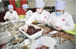  ??  ?? QUALITY CONTROL: Workers at a tea-processing plant sort the various leaves.