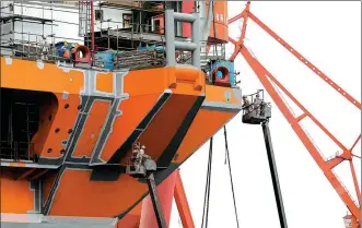  ?? YIN LIQIN / CHINA NEWS SERVICE ?? Workers administer antirust treatment on a hull at Shanghai Waigaoqiao Shipbuildi­ng Co Ltd on March 3.