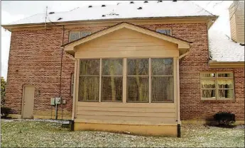  ??  ?? A 3-season room surrounded by large windows overlooks the wooded area at the edge of the backyard, which connects to Centennial Park.