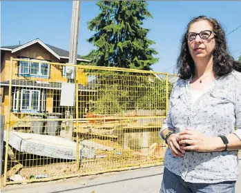  ?? GERRY KAHRMANN ?? Roanna Zuker stands in the alley near a house under constructi­on on Trinity Street that resulted in the removal of a 65-year-old Douglas fir. The city confirmed the tree “was deemed a hazard.”