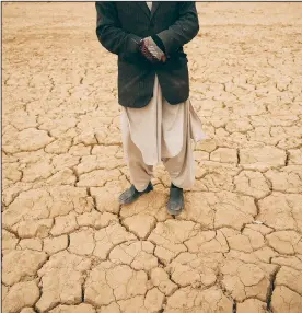  ?? ?? Abdul Haqim surveys Dec. 13 his barren field, where he used to grow wheat to feed his family of 18 people, in Hachka, Afghanista­n.