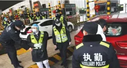  ?? ( Martin Pollard/ Reuters) ?? POLICE OFFICERS wearing masks check a car for smuggled wild animals following the outbreak of a new coronaviru­s on the eve of the Chinese Lunar New Year celebratio­ns, in Xianning.