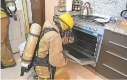  ?? QUINTANA ROO/PROSECUTOR'S OFFICE VIA AP ?? A firefighte­r in Tulum, Mexico, examines the condo where an Iowa family died. A water heater was the source of a gas leak.