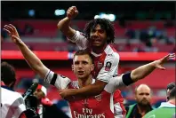  ??  ?? UPLIFTING: Substitute Mohamed Elneny celebrates Arsenal’s Wembley win with defender Per Mertesacke­r