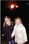  ??  ?? ●● Ava and Isla O’Brien enjoy the bonfire at the Tytheringt­on Club. Left, fireworks were set off at The Church House Inn, Sutton