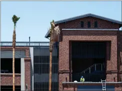  ?? ?? ABOVE AND BELOW: Constructi­on workers put final touches on a four-story parking structure at the corner of Stuart Avenue and Third Street in downtown Redlands.