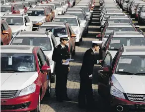  ?? CHINATOPIX VIA AP ?? Customs officials inspect cars being loaded for export at a port in China. The launch of a U.S. trade investigat­ion into whether the imports of autos and auto parts threaten national security is seen as a possible attempt by the U.S. to gain leverage...