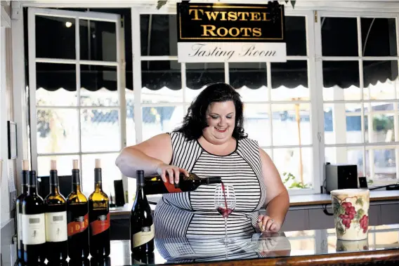  ?? Photos by Sarah Rice / Special to The Chronicle ?? Julie Ruiz pours wine at the Twisted Roots tasting room in Carmel Valley, which she opened with husband Josh Ruiz in 2012.