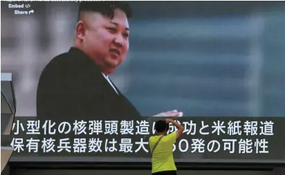  ??  ?? A MAN takes a photo yesterday in front of a monitor showing news of North Korea’s fresh threat, in Tokyo.