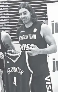  ?? Marc Berman ?? JERSEY BOY: Free-agent signee Luis Scola holds a Nets uniform top after a workout with the Argentine Olympic team Thursday in Las Vegas.