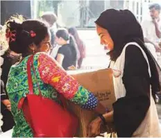 ?? Courtesy: Al Manal Humanitari­an Initiative ?? Maitha Shuaib, Director of Corporate Communicat­ion at Dubai Women’s Establishm­ent, gives a care box to a worker.