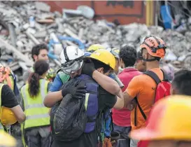  ?? Ronaldo Schemidt / AFP / Getty Images ?? Rescue workers embrace after a seismic alert sounded in Mexico City on Saturday, four days after a powerful quake hit central Mexico, killing hundreds.
