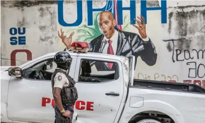  ?? Photograph: Valerie Baeriswyl/AFP/Getty Images ?? A police officer stands by a wall painted with a mural of the late Haitian president Jovenel Moïse, who was killed in July 2021.