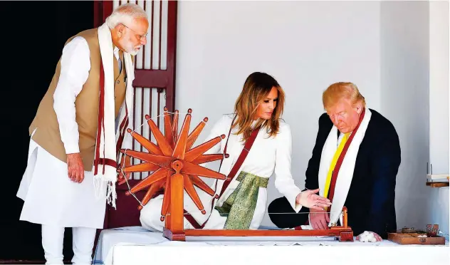  ?? Agence France-presse ?? ↑
Donald Trump and Melania Trump sit next to a spinning wheel as Narendra Modi looks on at Gandhi Ashram in Ahmedabad.